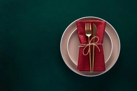 Dinner table setting with empty plates and golden cutlery on dark green bac.. Stock Photos