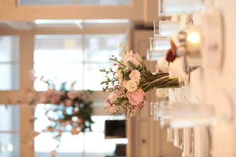 Dinner Table Setting with flowers and candles, soft warm pink peach tones Stock-Fotos