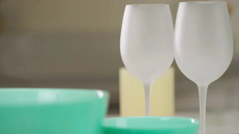 Dinner table setting. Green plates and wine glasses stand on the table. Set of Vídeo Stock 173541145