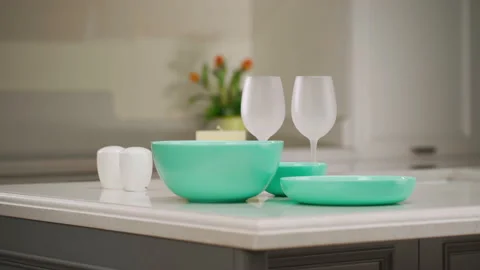 Dinner table setting. Green plates and wine glasses stand on the table. Set of Stockbeeldmateriaal 173544809