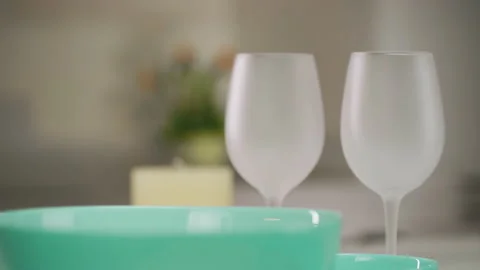 Dinner table setting. Green plates and wine glasses stand on the table. Set of Vídeo Stock 173546731