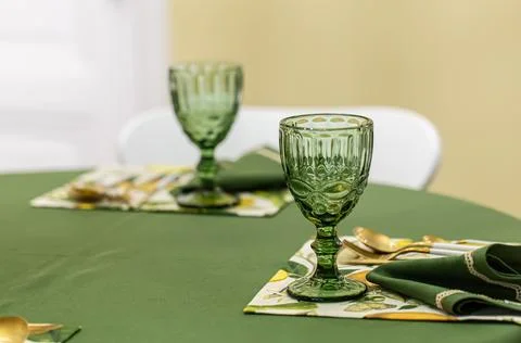 Dinner table setting idea with textured green glass goblets. Stock Photos