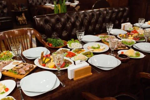 Dinner table setup with delicious food ready to be served Stock Photos