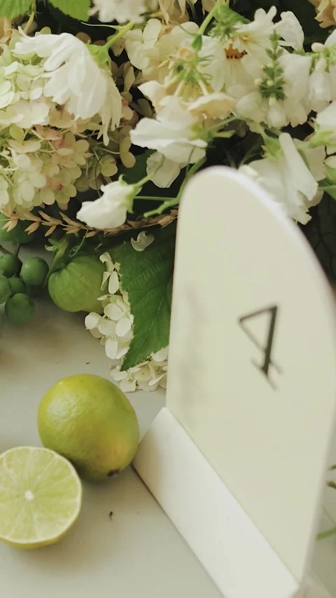 Dinner table setup flower. Elegant Floral Arrangement Featuring Citrus and Table Stock Footage 306366375