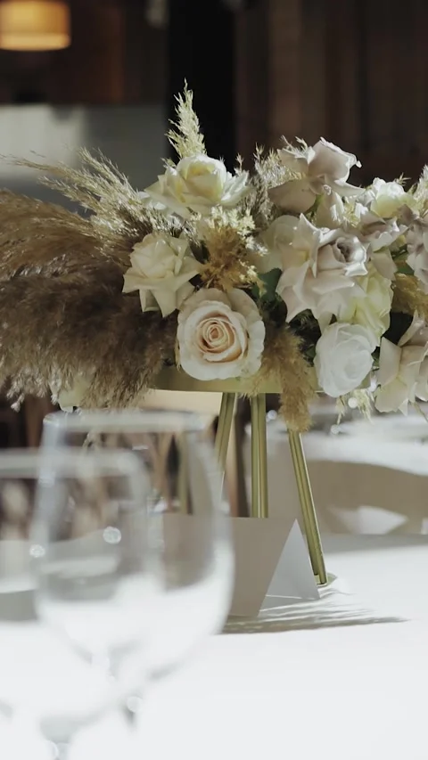 Dinner table setup flower. A wedding reception table set with a vase of flowers Stock Footage 308395668