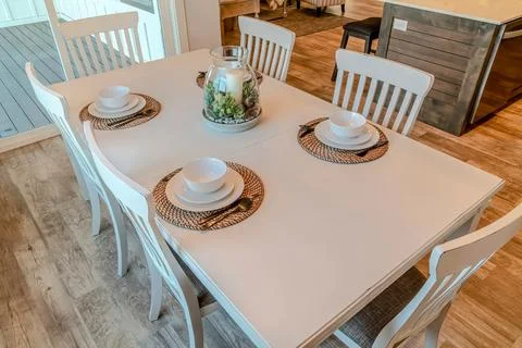 Dinner table with tableware for four persons arranged around candle centerpiece Stock Photos