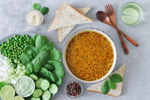 Dinner table top view with delicious soup and healthy green salad on stone ba Stock Photos
