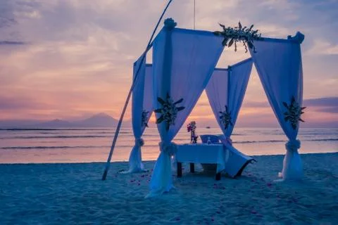 Dinner table for two on the beach in the sunset Stock Photos