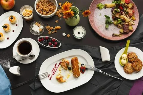 Dinner table with various dishes and drinks in a cozy setting Stock Photos