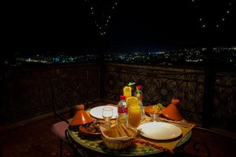 Dinner table with wicker lamp at night in the terrace of a riad Stock Photos