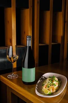 Dinner table with wine and shrimp dish at restaurant in evening Stock Photos