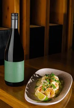 Dinner table with wine and shrimp dish at restaurant in evening Stock Photos