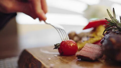 Dinner time closeup to the camera a man take the knife and start to eat his Stock Footage 156176241