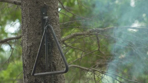 Dinner Triangle Hanging above Smoking Grill Stock Footage 87040501