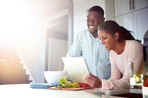 Dinners sorted thanks to digital technology. a young couple using a digital Stock Photos