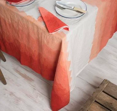 Dinnerware and Napkin on Table Covered in Gradient Orange Zigzag Linen Stock Photos