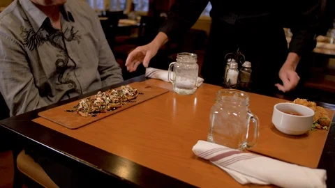Dinning close view of table and 2 guest being served apps Stock Footage 105320115