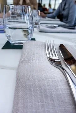 Dinning fork and knife on a table napkin Stock Photos