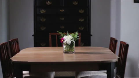 Dinning room table with flowers. Simple wooden table in dining room with chairs  Stock Footage 152487097