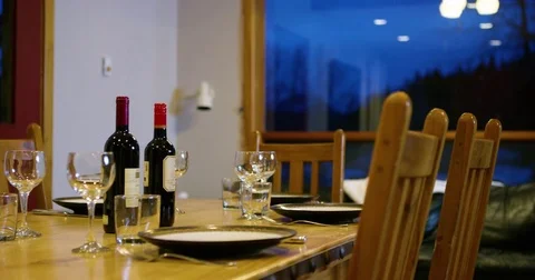 Dinning table set with plates, spoons, forks, wine bottle and glasses Stock Footage 80633204