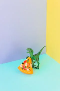 Dinosaur eats slice of pizza Stock Photos