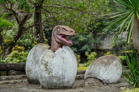 A dinosaur egg is sitting on top of a broken egg Stock Photos