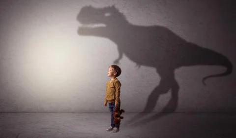 Dinosaurus shadow behind cute boy Stock Photos