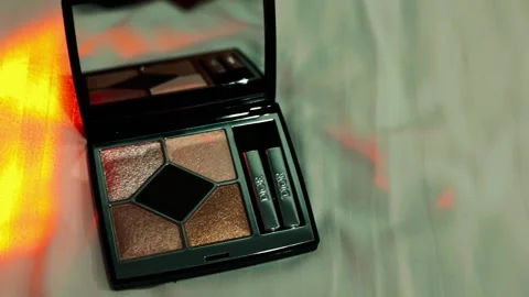 Dior eyeshadow palette and an array of warm, fiery colors lights Stock Footage 308746127