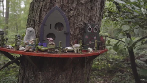Diorama of tiny statues around a tree trunk plateau in a forest Stock Footage 154396112
