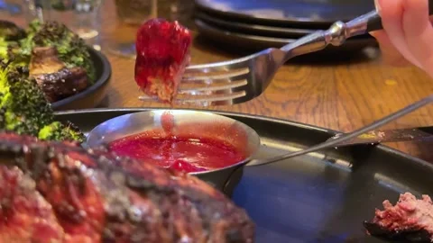 Dip beef in cranberry sauce Steak dinner wine Vídeo Stock 323921400