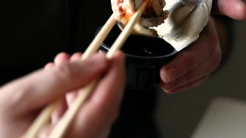 Dip sushi roll with eel in soy sauce for flavo Stock Footage 303521227