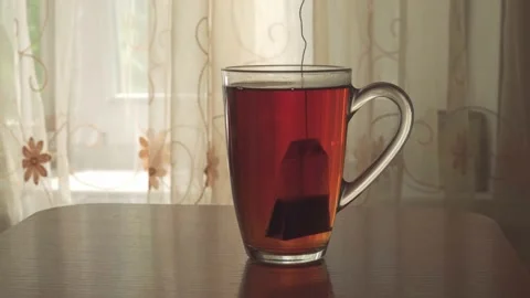 Dip the tea bag in boiling water, which is poured into a glass tea cup. Video stock 192760065