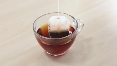 Dipping and Steeping a Tea Bag in a Glass Cup Stock Footage 346017243