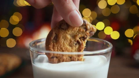 Dipping a Bitten Chocolate Chip Cookie in Glass of Milk in Slow Motion Stock Footage 208931481