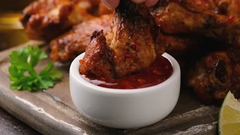 Dipping buffalo chicken wings in sweet chili sauce. fast food. Stock Footage