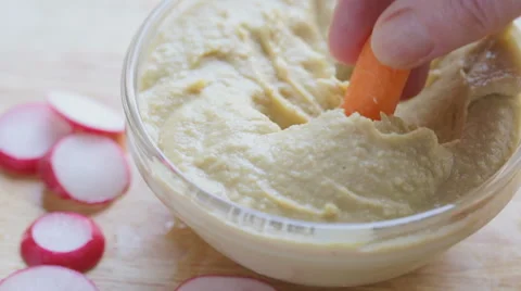 Dipping Carrot into Hummus Video stock 65279197