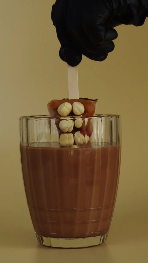 Dipping Cheesecake Pops with Caramel and Hazelnuts in Chocolate Stock Footage 342039345