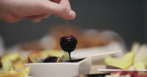 Dipping cherry into dark premium liquid chocolate, slow motion isolated cinem Stock Footage 330100013