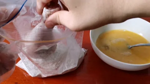 Dipping Chicken Legs in a Flour Mixture Stock Footage 161006063