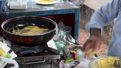 Dipping of chillies in batter and deep frying them. 库存影片 159611276