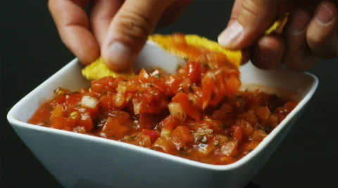 Dipping chips in salsa Stock Footage