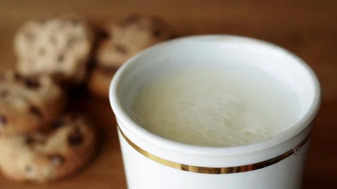 Dipping chocolate chips cookie in milk Stock Footage 76718725