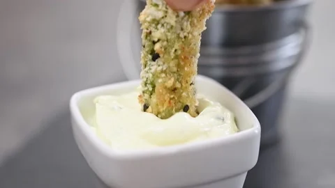 Dipping crispy baked courgette stick in a sauce. 스톡 동영상 150890031