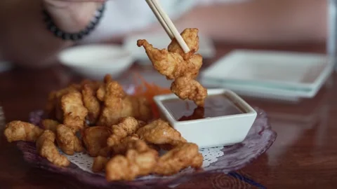 Dipping crispy fried chicken karaage into savory sauce with chopsticks Stock Footage 336264511