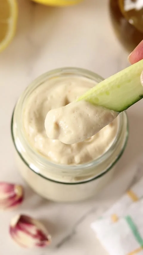Dipping cucumber slice in a jar of homemade mayonnaise Stock Footage 337418213