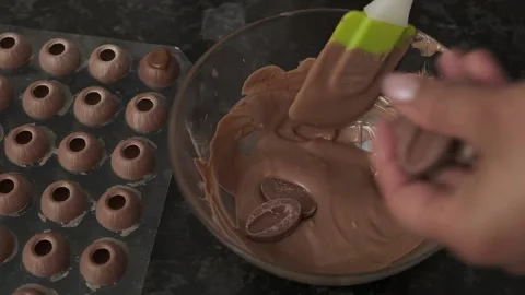Dipping dark chocolate in a cream. Vídeos de archivo 132865844