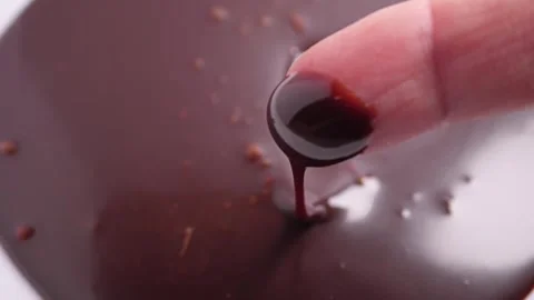 Dipping a finger in chocolate syrup Видео 296240987