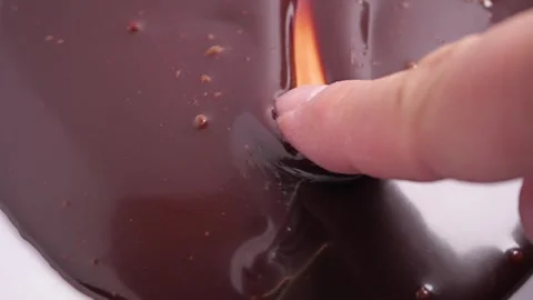 Dipping a finger in chocolate syrup Stock-Footage 296241003