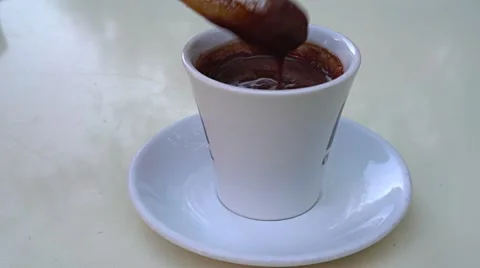 Dipping a freshly fried churro into a cup of hot chocolate in Granada, Spain. Видео 57330541