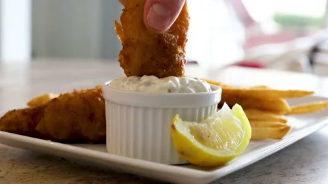 Dipping a Fried Piece of Fish into Tarter Sauce Stock Footage 145800562